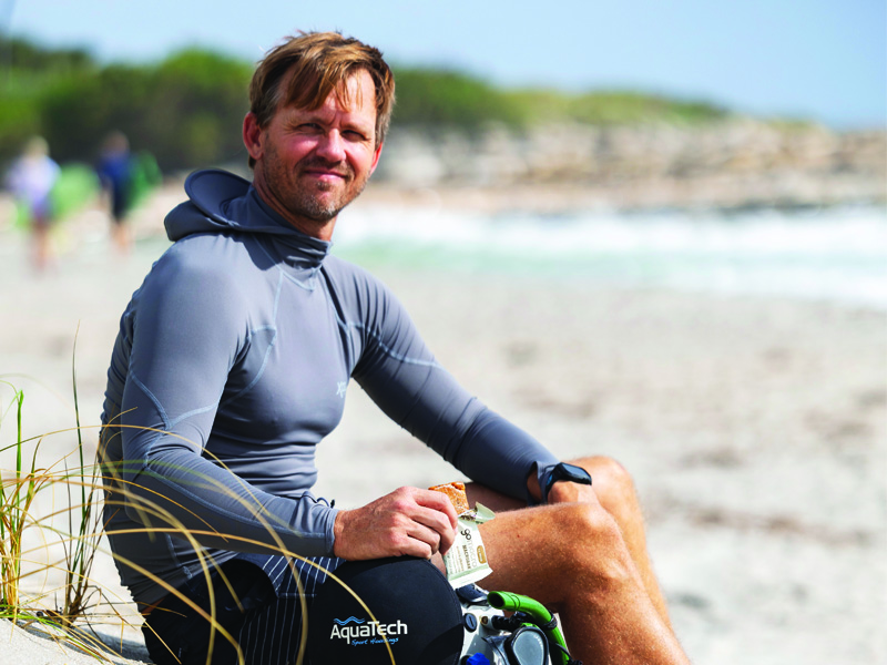 GoMacro Ambassador at the beach holding a GoMacro MacroBar